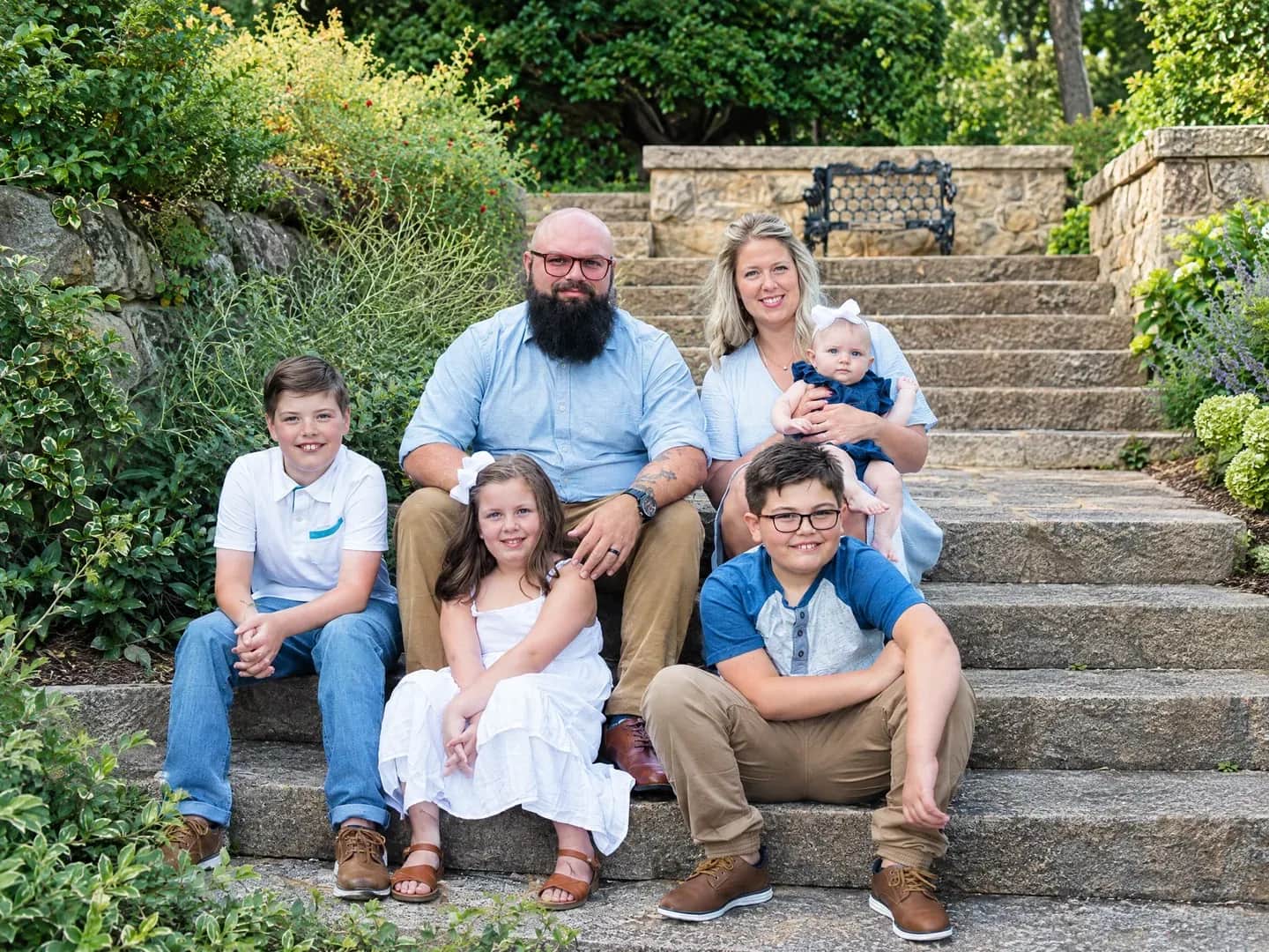 A family with their dog on garden steps.